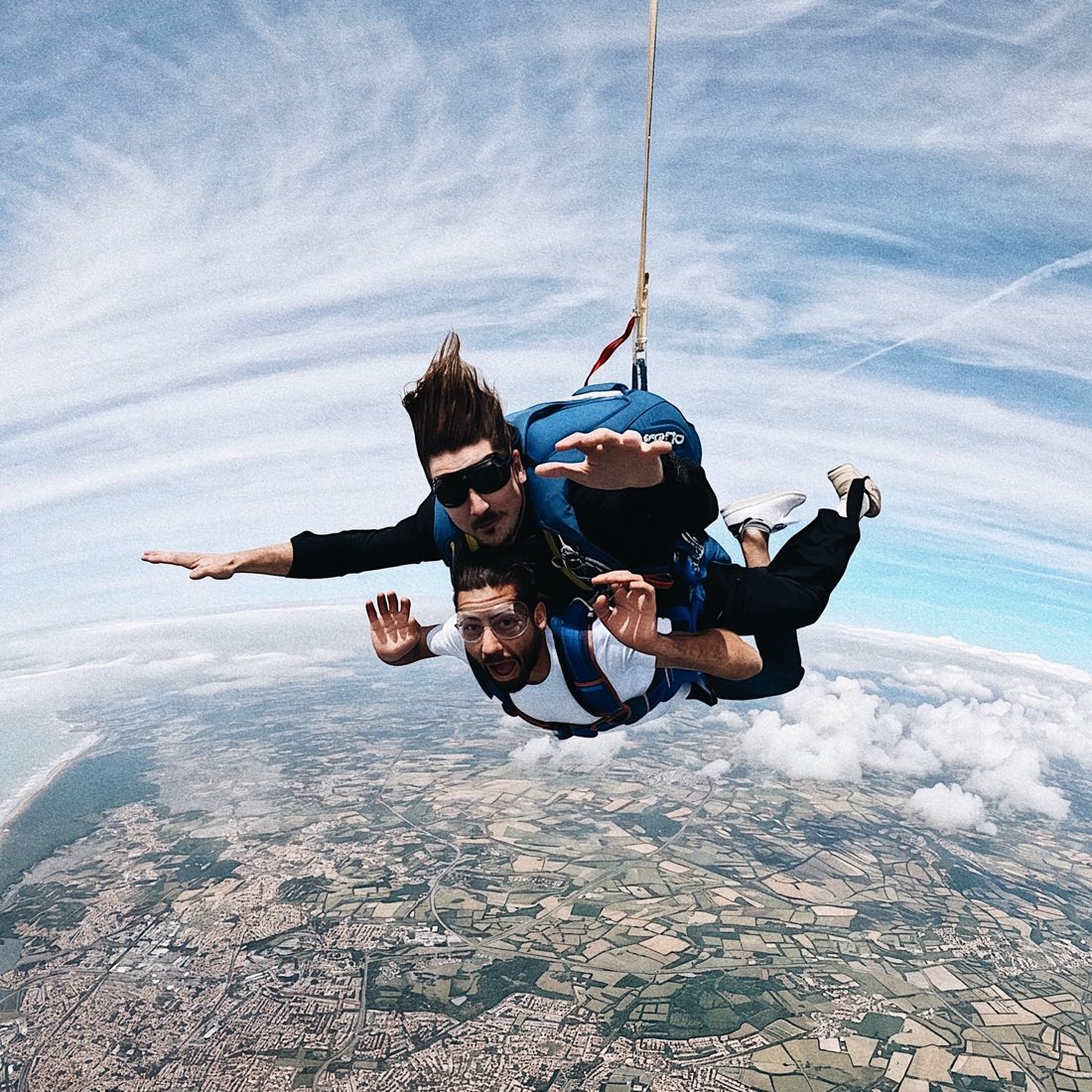 Gaspar en chute libre, harnaché à un passager en tandem, au-dessus de la côte