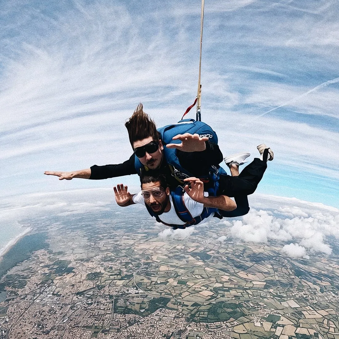 Gaspar en chute libre, harnaché à un passager en tandem, au-dessus de la côte