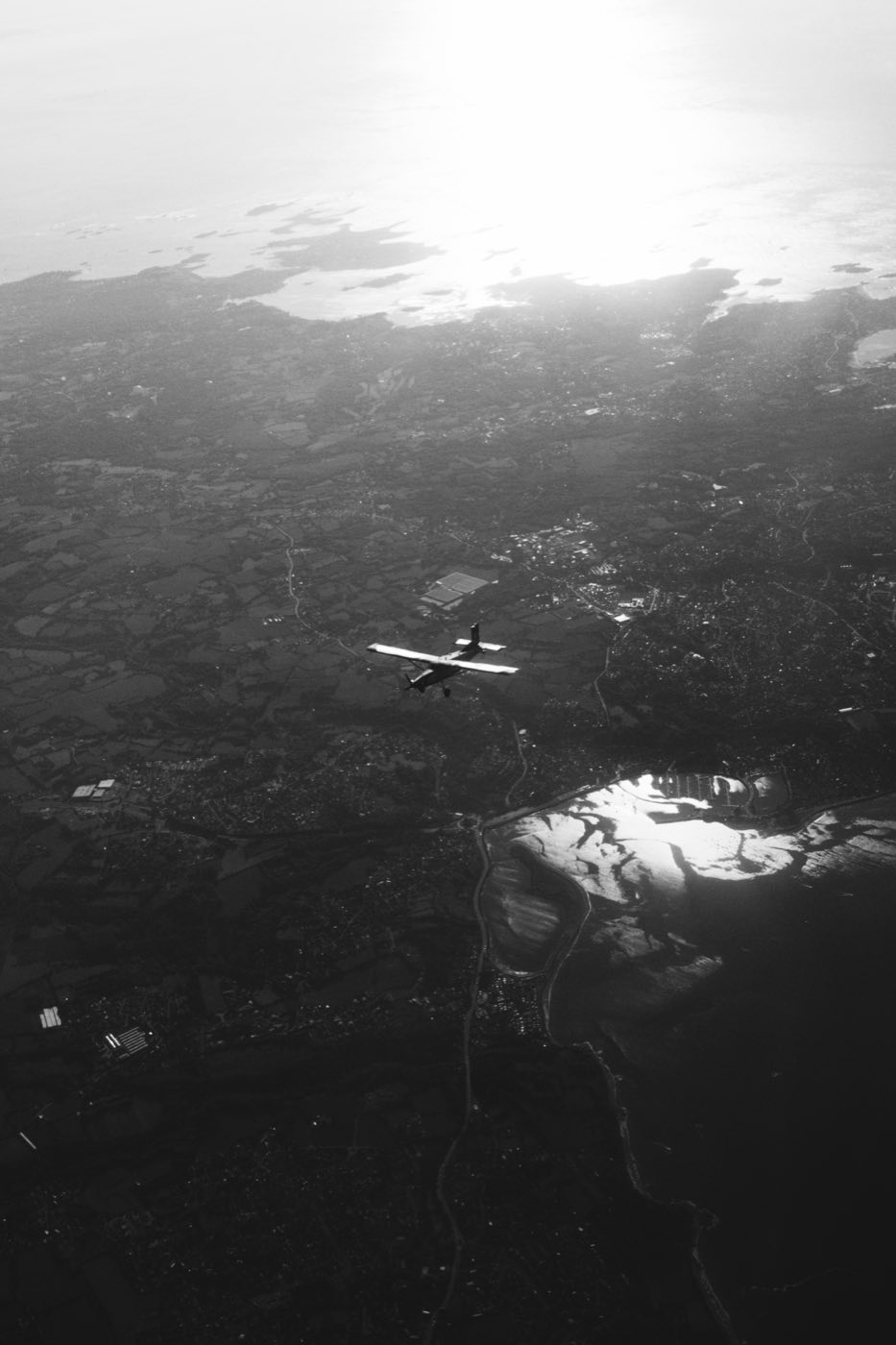 Vue aérienne en noir et blanc d'un avion survolant la côte