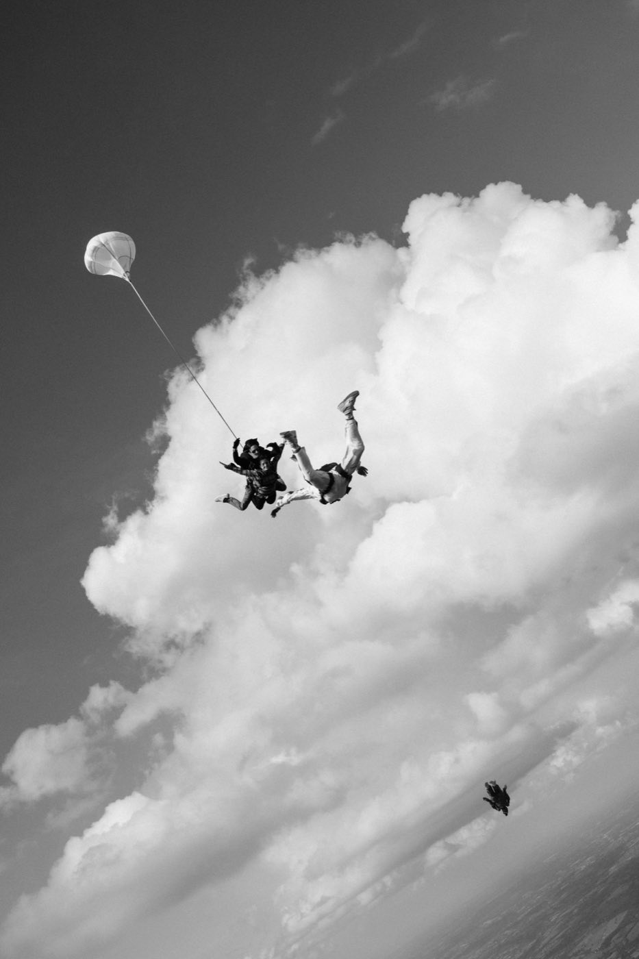 Un tandem en chute libre à côté d'un gros cumulus