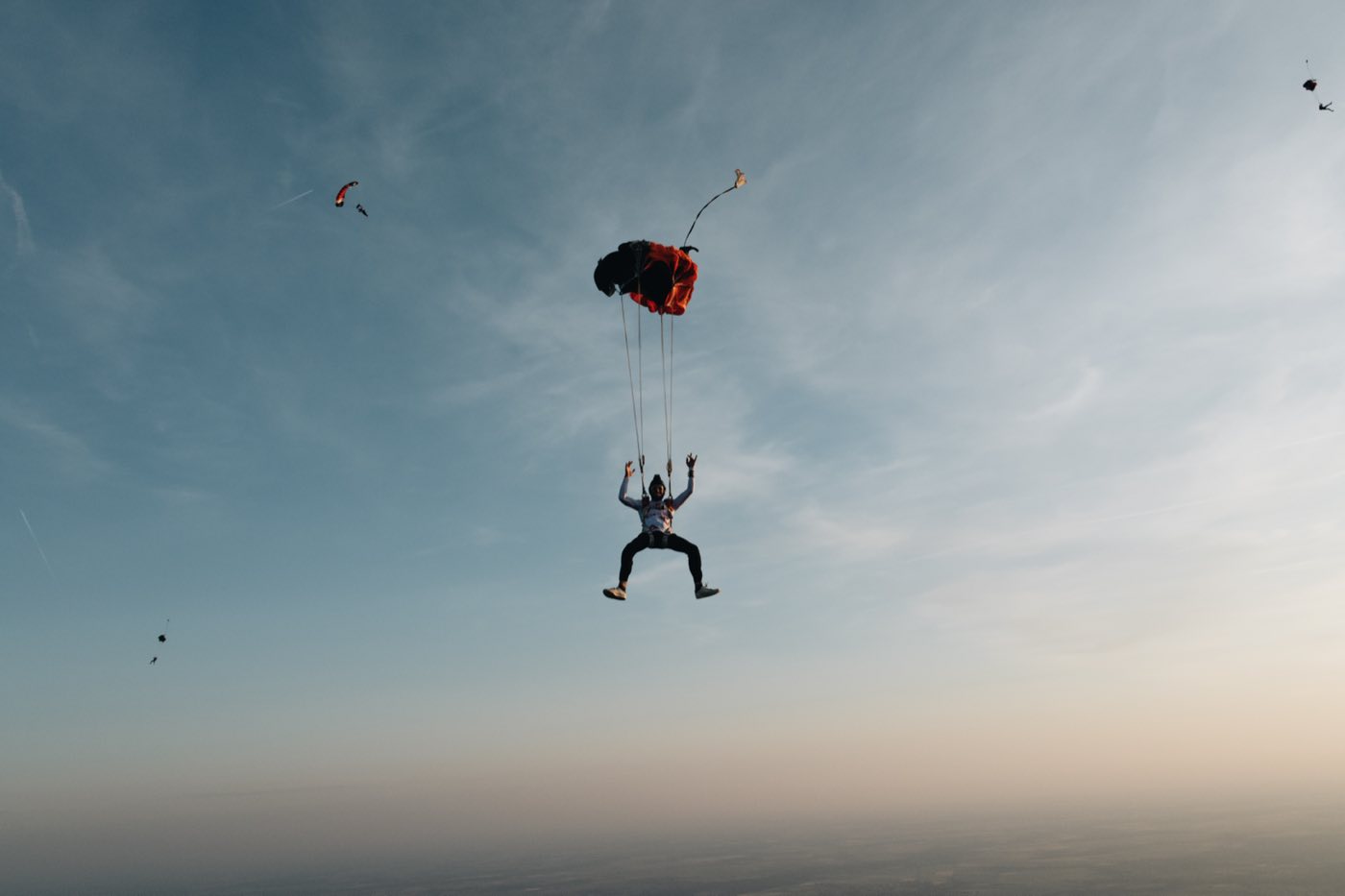 Deux parachutistes sous voile dans la lumière de fin de journée